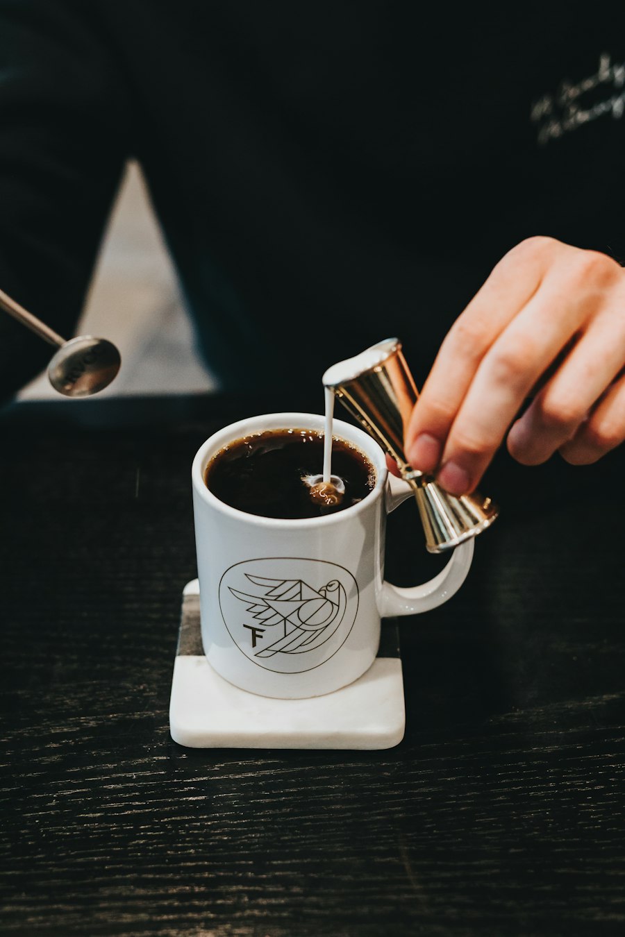 Milk being poured into a cup of coffee